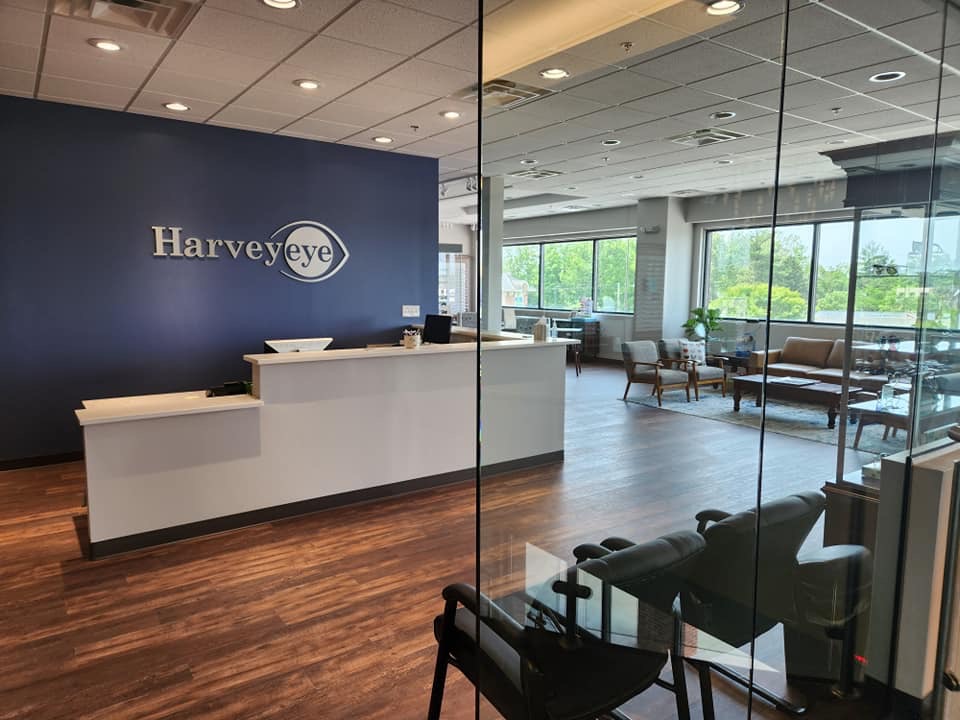 Harveyeye reception desk with the Harveyeye logo on a navy accent wall