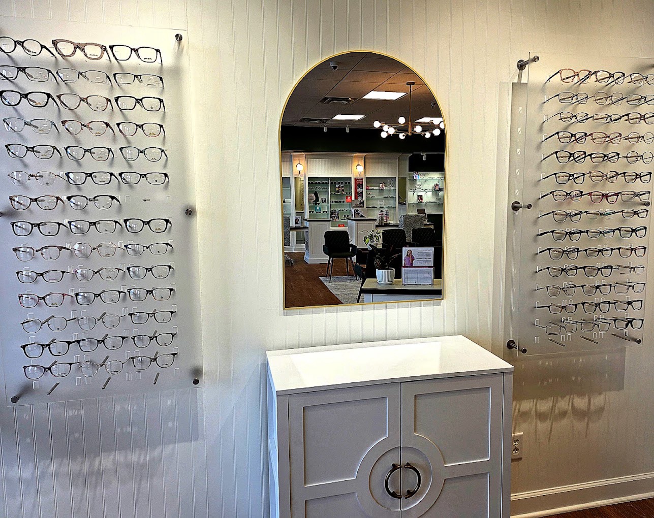 Designer frame boards flanking an arched mirror in the optical showroom at Harvey Eye Brownsboro Road