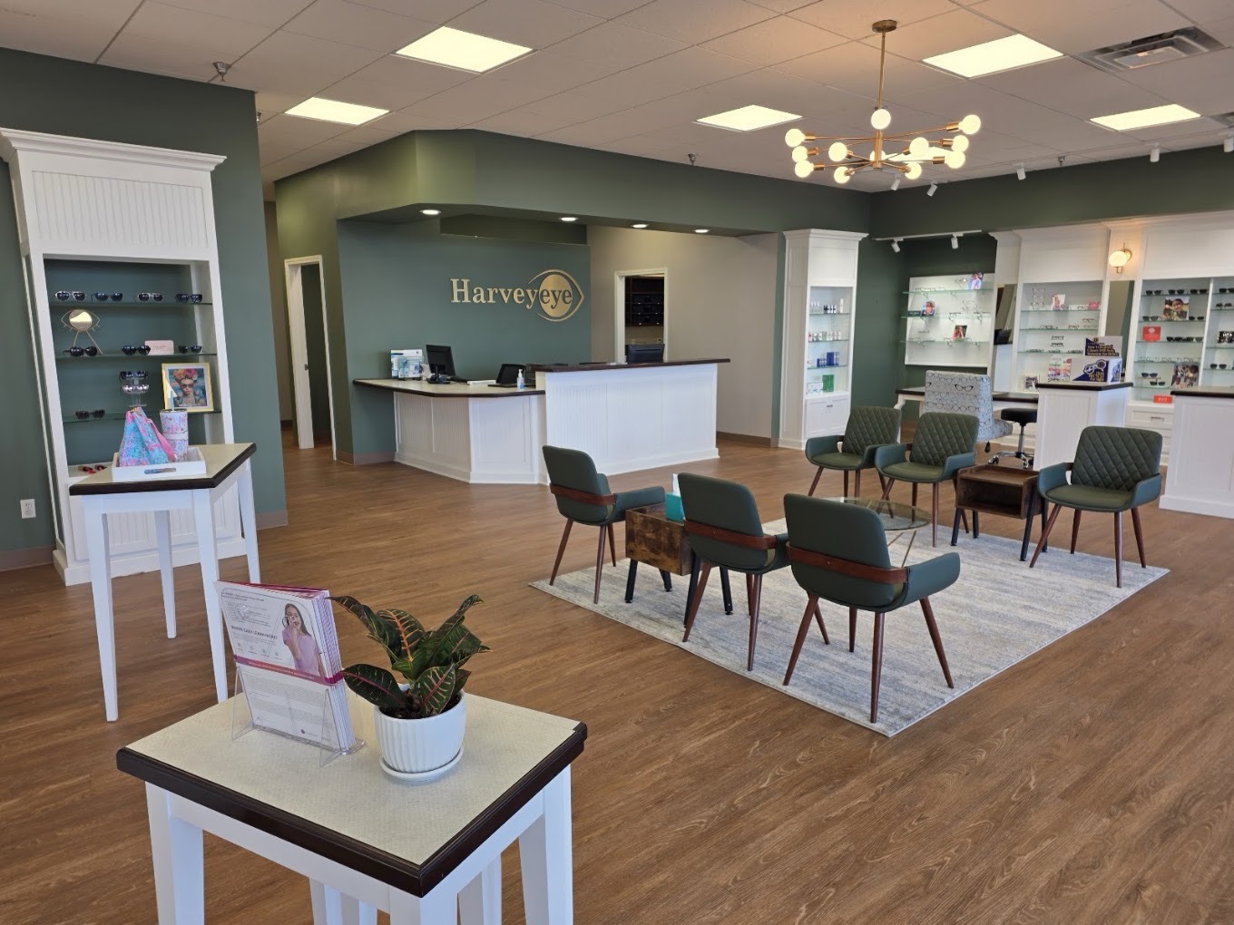 Harveyeye reception desk with logo on a sage green accent wall at the Brownsboro Road office